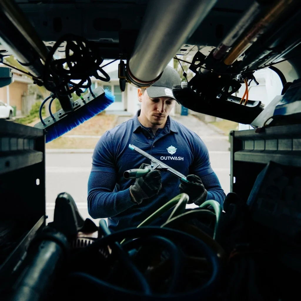 Outwash technician preparing cleaning gear inside a company vehicle before a Toronto window cleaning job.