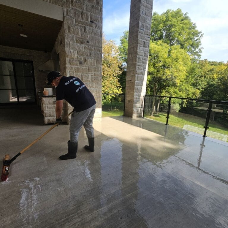 Outwash technician scrubbing a wet stone terrace