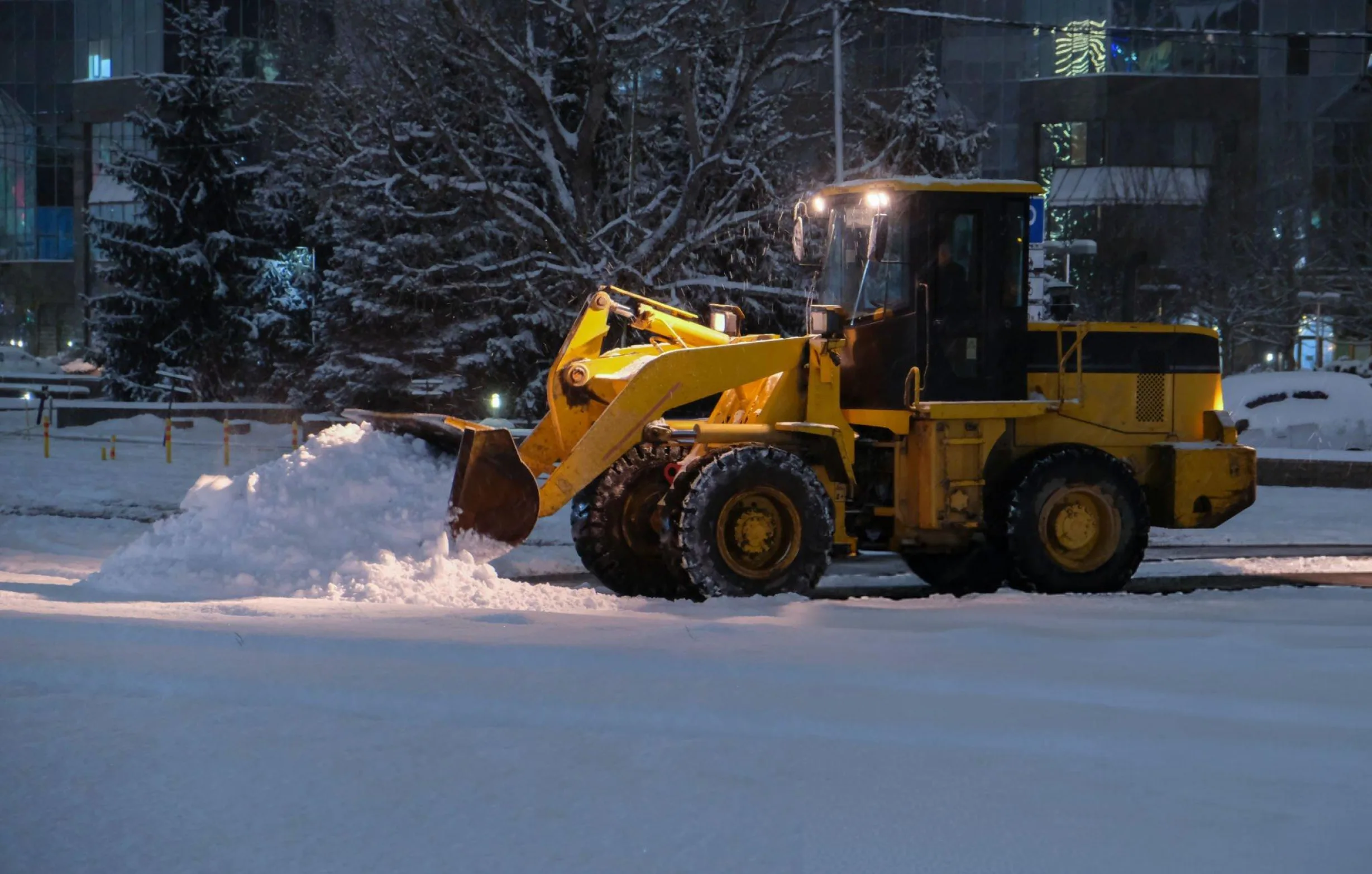 Dump truck loading snow from commercial lot