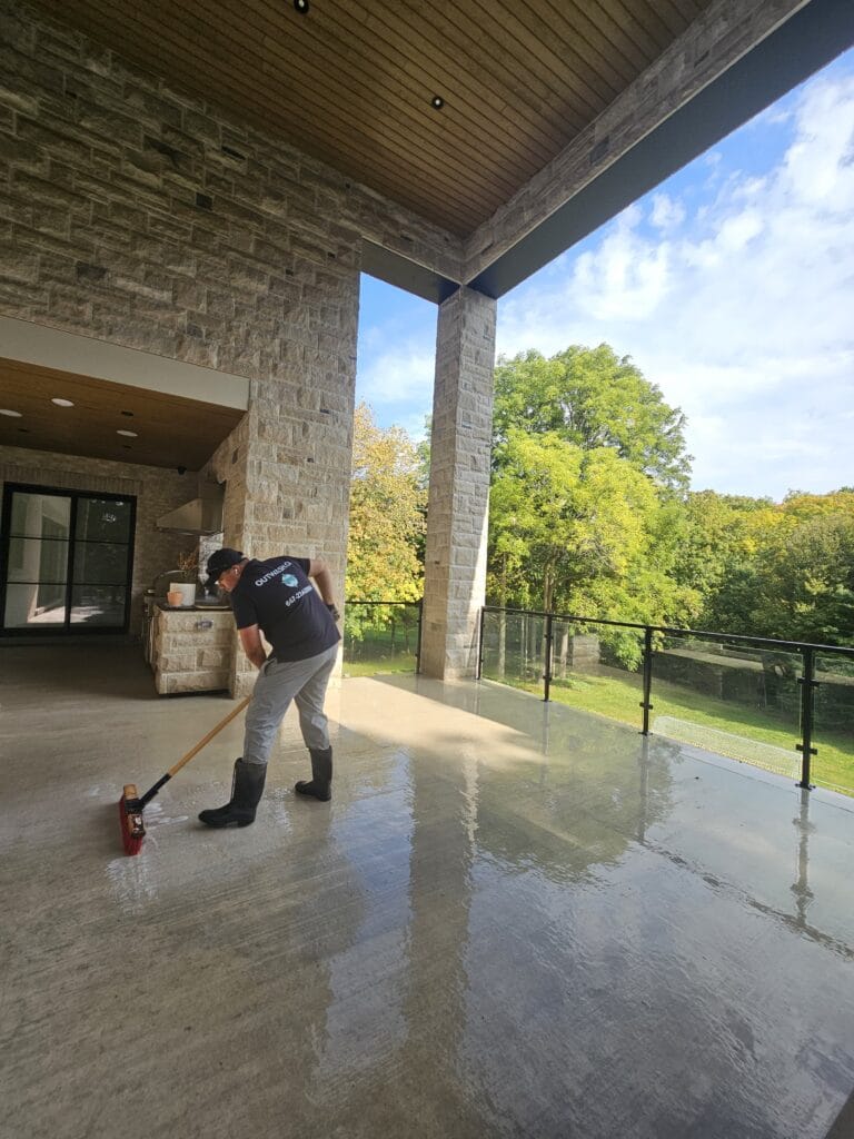 Outwash technician scrubbing a covered stone terrace
