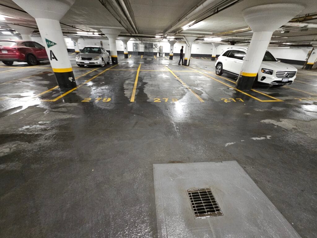 Wet concrete floor and a drain in an underground parking garage