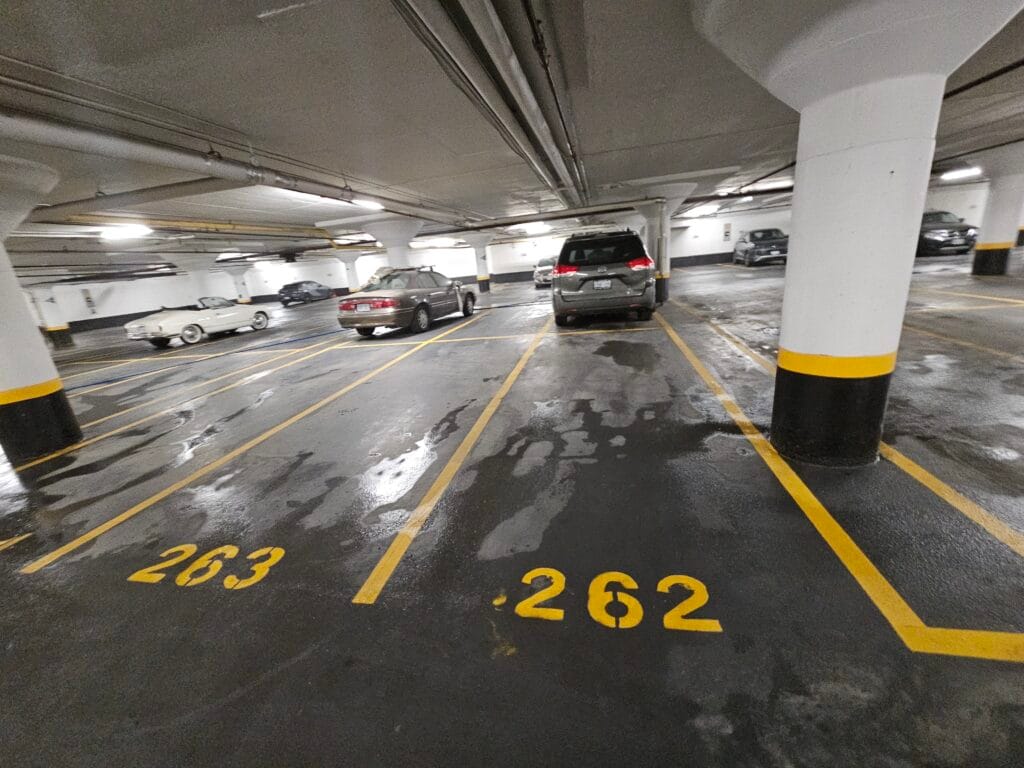 Wet floor and numbered stalls in an underground parking garage