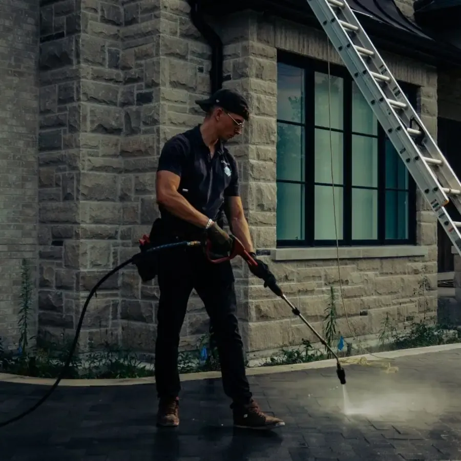 Outwash technician pressure washing a paved driveway