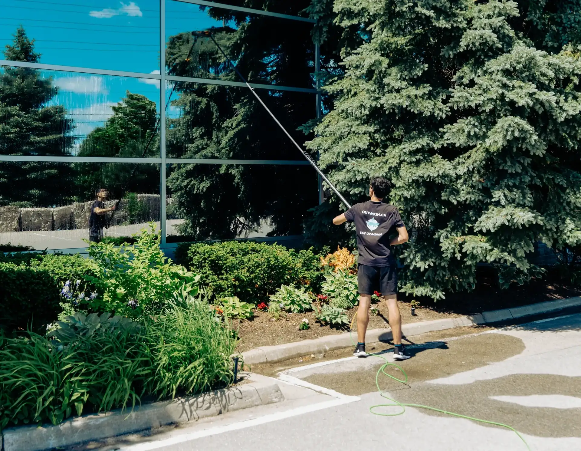 Outwash technician cleaning hotel windows with a water-fed pole